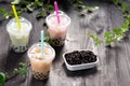 Variety of bubble tea in plastic cups with straws on a wooden ta Royalty Free Stock Photo