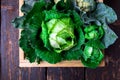 Variety of cabbages in wooden basket on brown background. Harvest. Top view. Royalty Free Stock Photo