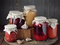 Variety of canned vegetable food: conserved beetroot, tomato paste, preserved bean, jam, pickles on wooden rustic background