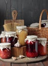 Variety of canned vegetable food: conserved beetroot, tomato paste, preserved bean, jam, pickles on wooden rustic background