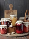 Variety of canned vegetable food: conserved beetroot, tomato paste, preserved bean, jam, pickles on wooden rustic background