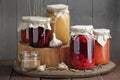 Variety of canned vegetable food: conserved beetroot, tomato paste, preserved bean, jam, pickles on wooden rustic background