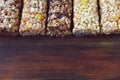 Variety of cereal bars with nuts, seeds, dried fruits and chocolate on the wooden table,top view. Royalty Free Stock Photo