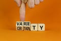 Variety or certainty symbol. Concept words Variety or certainty on wooden cubes. Businessman hand. Beautiful orange table orange