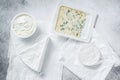 Variety of cheese kinds on kitchen table, brie, Camembert, Gorgonzola and blue creamy cheese. White background. Top view