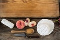 Variety of cheese with peach, spoon, knife and chopping board