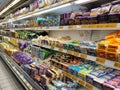 A variety of cheeses and butter are displayed on sales shelves in hypermarkets.