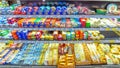 variety of cheeses in the refrigerated display case In a large supermarket.