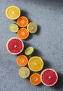 Variety of citrus fruits on a grey background, top view. Oranges, grapefruit, tangerine, lime, lemon - organic fruits, vegetarian