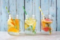 Variety of citrus infused detox water drinks in mason jars against blue wood Royalty Free Stock Photo