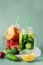 Variety of Cold Summer Drinks in Glass Jars Infused Detox Water with Cucumber Lemon and Strawberry Healthy Drink Green Background Royalty Free Stock Photo