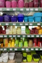 Variety of colorful flower pots are sold at the store. Rows of different pots for indoor plants on shelves in a mall. Vertical