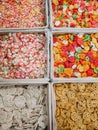 A variety of colorful raw crackers of various flavors and sizes in their respective boxes at a stall