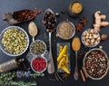 Variety of colorful spices and herbs on black stone background, top view Royalty Free Stock Photo