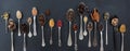 Variety of colorful spices in spoons on black stone background, top view, banner Royalty Free Stock Photo