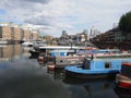 A variety of colourful houseboats at Limehouse Marina in east London with apartments in the background