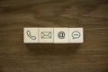 Variety of contact approach. Icon of phone, email, post and chat on a wooden cube