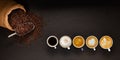 Variety of cups of coffee and coffee beans in burlap sack on black background Royalty Free Stock Photo