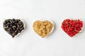 Variety of currant berries black, red and white in heart shape bowls on white marble background. summer food concept Royalty Free Stock Photo