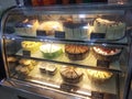 A variety of decorative cakes are placed on a glass chiller rack to make it easier for customers to choose.