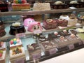 A variety of decorative cakes are placed on a glass chiller rack to make it easier for customers to choose.