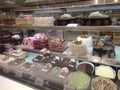 A variety of decorative cakes are placed on a glass chiller rack to make it easier for customers to choose.