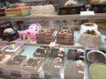 A variety of decorative cakes are placed on a glass chiller rack to make it easier for customers to choose.