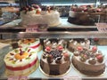 A variety of decorative cakes are placed on a glass chiller rack to make it easier for customers to choose.