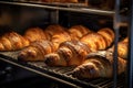 A variety of delicious croissants in different flavors and shapes arranged neatly on a rack, ready for purchase, fresh croissants