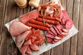 Variety of delicious deli meats on wooden table Royalty Free Stock Photo