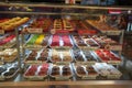 Variety of delicious donut in showcase on display at bakery cake shop Krispy Kreme. Various donuts type on shelf in Bakery shop.