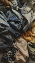 A variety of different colored clothes piled on top of each other, creating a stack of laundry. The clothes appear to be