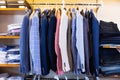 Variety of different suit jackets exposed on clothing rack in men clothes shop