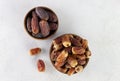 Variety of dried dates fruits in a wooden bowl on a white background. Top view