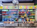 A variety of drinks in plastic and glass bottles on the shelves of a Narvesen store