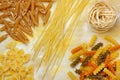 Variety of dry raw pastas over painted textile background Royalty Free Stock Photo