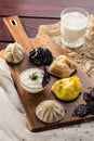 Variety of dumplings manti and khinkali with sour cream on wooden board on wooden table Royalty Free Stock Photo