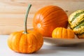 Variety of fall pumpkins and squash close up, wooden background