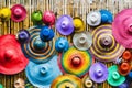 Variety of fashionable and colorful hats hanging on bamboo backdrop of curbside shop. Tourism designer straw hats from the sun of