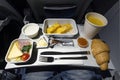 variety of food on the folding table on the plane. Late dinner during the flight at night