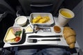 variety of food on the folding table on the plane. Late dinner during the flight at night Royalty Free Stock Photo