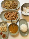 variety of food on the platethere are 6 plates containing food such as fried noodles, white rice, crackers, soup and others