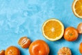 Variety of fresh citrus fruits for making juice or smoothie over blue textured background, top view, selective focus. Royalty Free Stock Photo