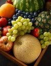 Variety of fresh fruits and berries in wooden box. Healthy vegetarian summer food Royalty Free Stock Photo