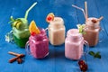 Variety of Fresh Healthy Paleo Smoothies and Cocktails in Rainbow Colors on Blue Wooden Background