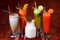 Variety of Fresh Healthy Paleo Smoothies and Cocktails in Rainbow Colors on Wooden Background, Beach Party