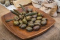 A variety of fresh olives, produce and other healthy foods are artfully arranged on a wooden plate Royalty Free Stock Photo