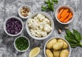 Variety of fresh vegetables in bowls - potatoes, red and cauliflower, spinach, green onions, carrots, nuts, olive oil, cilantro. Royalty Free Stock Photo