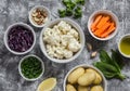 Variety of fresh vegetables in bowls - potatoes, red and cauliflower, spinach, green onions, carrots, nuts, olive oil, cilantro. Royalty Free Stock Photo