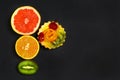 Variety of fruits grapefruit, oranges, kiwi, cake, sweet fruit dessert bunched together on a shale board, the concept of healthy e